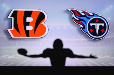 Cincinnati Bengalleri, Tennessee Titanları 'na karşı. NFL oyunu. Amerikan Futbol Ligi maçı. Profesyonel oyuncunun silueti dokunuşu kutluyor. Arkaplanda ekran.