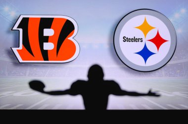 Cincinnati Bengal, Pittsburgh Çelik 'e karşı. NFL oyunu. Amerikan Futbol Ligi maçı. Profesyonel oyuncunun silueti dokunuşu kutluyor. Arkaplanda ekran.