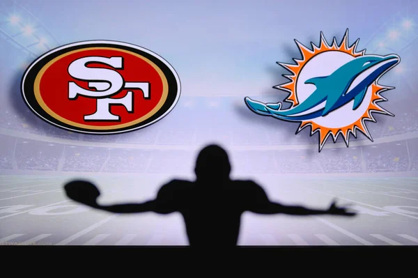 San Francisco 49ers Miami Dolphins 'e karşı. NFL oyunu. Amerikan Futbol Ligi maçı. Profesyonel oyuncunun silueti dokunuşu kutluyor. Arkaplanda ekran.