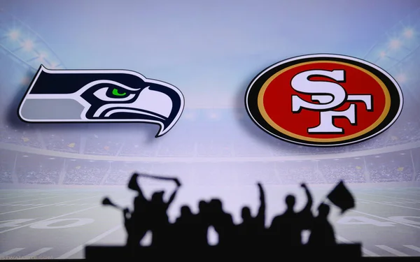 stock image Seattle Seahawks vs. San Francisco 49ers. Fans support on NFL Game. Silhouette of supporters, big screen with two rivals in background.