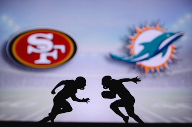 San Francisco 49ers Miami Dolphins 'e karşı. NFL maç posteri. Sahada karşı karşıya gelen iki Amerikan futbolcu silueti. Arka planda kulüp logosu var. Rekabet konsepti fotoğrafı.