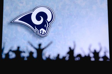 Los Angeles Rams. Taraftarlar Amerikan Ulusal Foorbol Ligi 'nin profesyonel takımını destekliyor. Taraftarların silueti ön planda. Büyük ekranda logo.