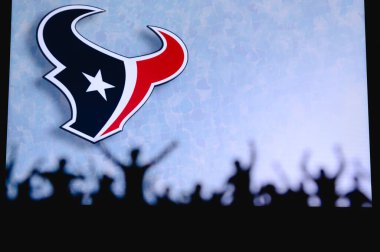Houston Teksaslıları. Taraftarlar Amerikan Ulusal Foorbol Ligi 'nin profesyonel takımını destekliyor. Taraftarların silueti ön planda. Büyük ekranda logo.