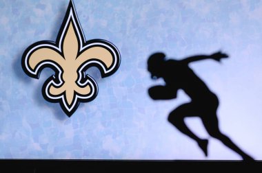 New Orleans Azizleri. Profesyonel Amerikan futbolcusunun silueti. Arka planda NFL kulübünün logosu, boşluğu düzenle.