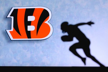 Cincinnati Bengalleri. Profesyonel Amerikan futbolcusunun silueti. Arka planda NFL kulübünün logosu, boşluğu düzenle.