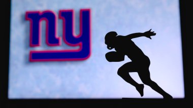 New York Devleri. Profesyonel Amerikan futbolcusunun silueti. Arka planda NFL kulübünün logosu, boşluğu düzenle.