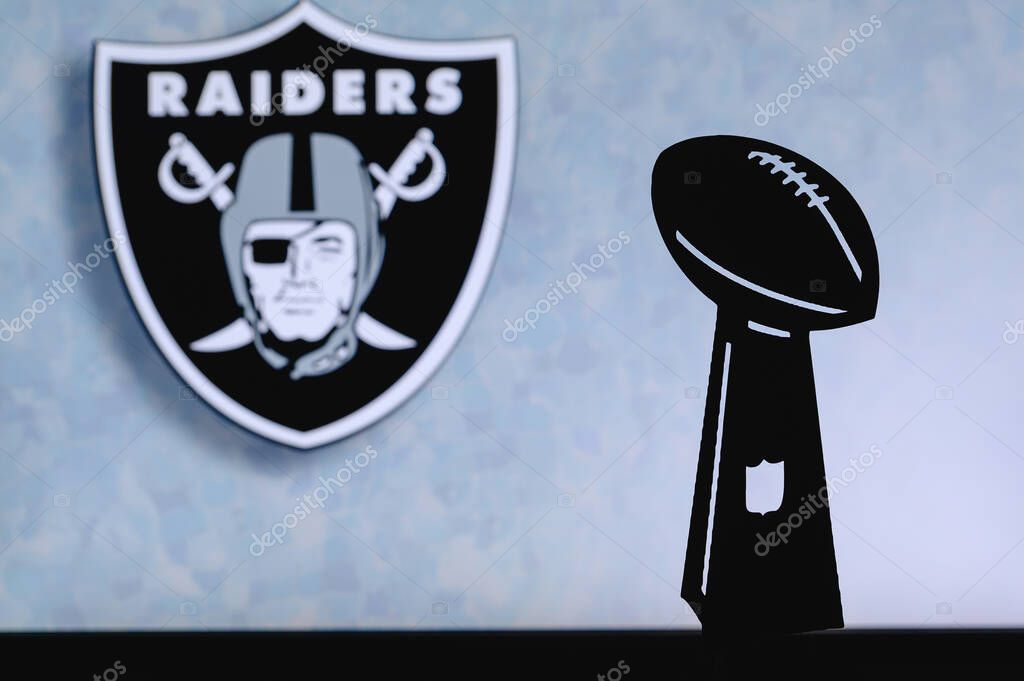 Las Vegas Raiders professional american football club, silhouette of NFL trophy, logo of the club in background.