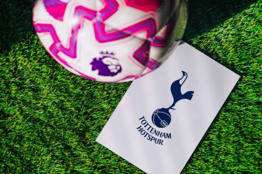 VIENNA, AUSTRIA, MAY 26, 2025: Tottenham Hotspur logo of football club of Premier League. Official ball for season 2025 and 2026. And logo of soccer club in major British league on green grass