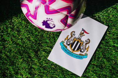 VIENNA, AUSTRIA, MAY 26, 2025: Newcastle United logo of football club of Premier League. Official ball for season 2025 and 2026. And logo of soccer club in major British league on green grass
