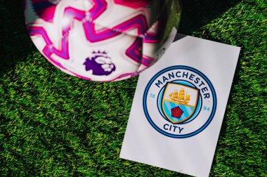 VIENNA, AUSTRIA, MAY 26, 2025: Manchester City logo of football club of Premier League. Official ball for season 2025 and 2026. And logo of soccer club in major British league on green grass