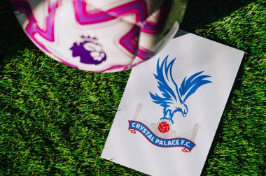 VIENNA, AUSTRIA, MAY 26, 2025: Crystal Palace logo of football club of Premier League. Official ball for season 2025 and 2026. And logo of soccer club in major British league on green grass