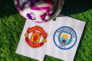 VIENNA, AUSTRIA, MAY 26, 2025: Manchester United vs Manchester City derby football match in Premier League. Club logo and official ball on green soccer grass. Manchester Derby.