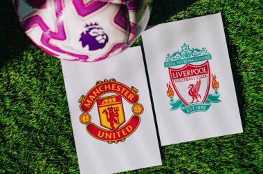 VIENNA, AUSTRIA, MAY 26, 2025: Manchester United vs Liverpool derby football match in Premier League. Club logo and official ball on green soccer grass. Northwest Derby