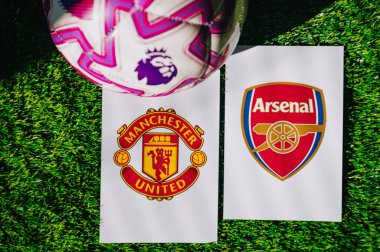 VIENNA, AUSTRIA, MAY 26, 2025: Manchester United vs Arsenal derby football match in Premier League. Club logo and official ball on green soccer grass.