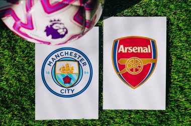 VIENNA, AUSTRIA, MAY 26, 2025: Manchester City vs Arsenal derby football match in Premier League. Club logo and official ball on green soccer grass.