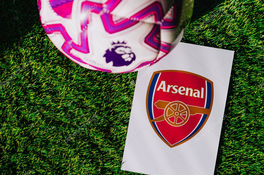 VIENNA, AUSTRIA, MAY 26, 2025: Arsenal logo of football club of Premier League. Official ball for season 2025 and 2026. And logo of soccer club in major British league on green grass