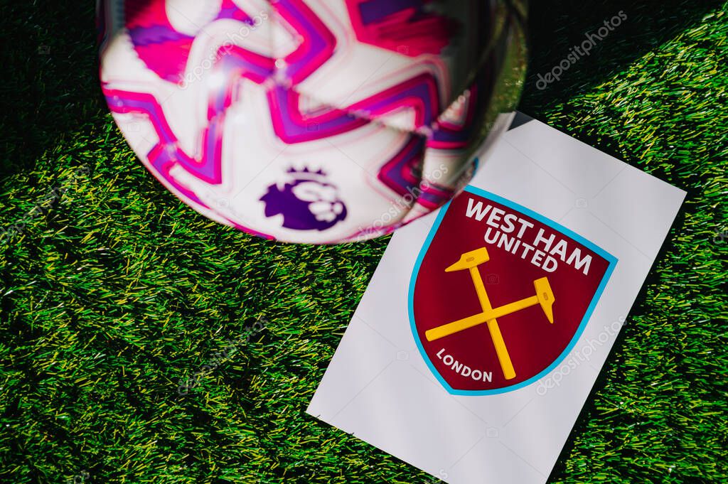 VIENNA, AUSTRIA, MAY 26, 2025: West Ham United logo of football club of Premier League. Official ball for season 2025 and 2026. And logo of soccer club in major British league on green grass