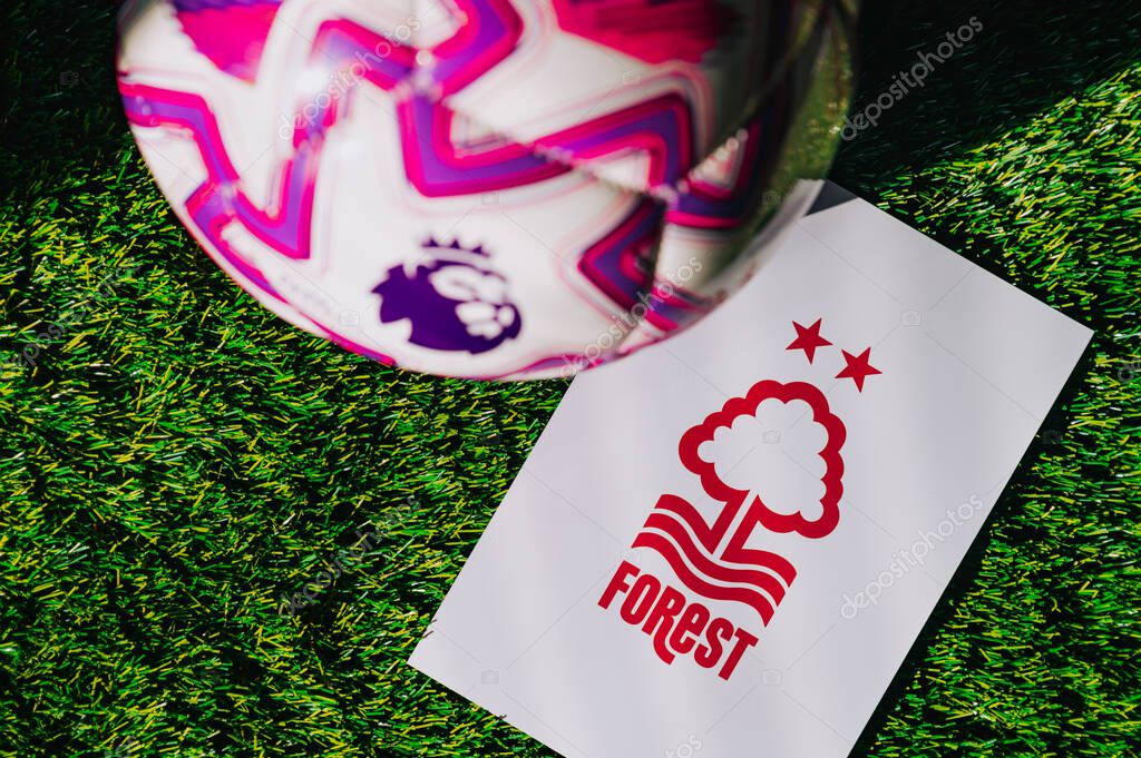 VIENNA, AUSTRIA, MAY 26, 2025: Nottingham Forest logo of football club of Premier League. Official ball for season 2025 and 2026. And logo of soccer club in major British league on green grass