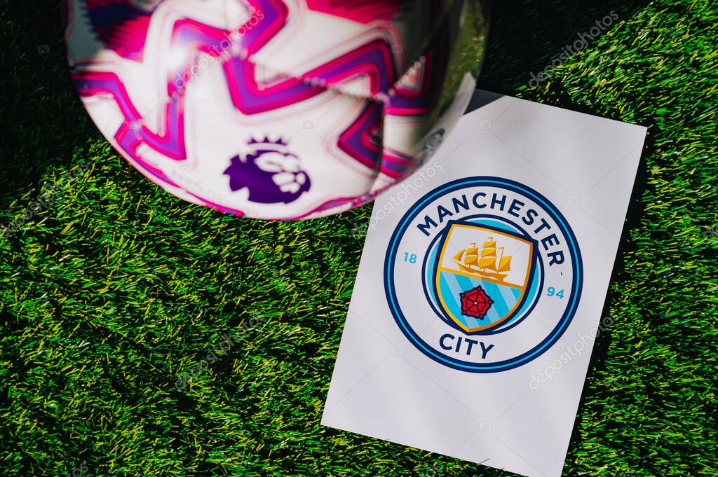 VIENNA, AUSTRIA, MAY 26, 2025: Manchester City logo of football club of Premier League. Official ball for season 2025 and 2026. And logo of soccer club in major British league on green grass
