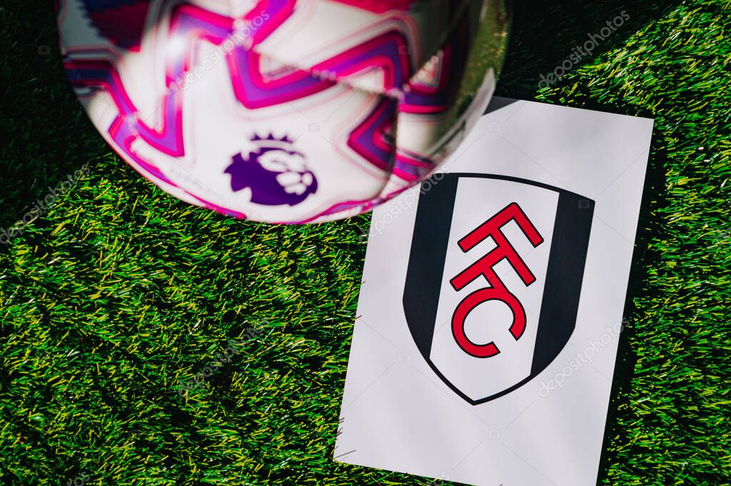 VIENNA, AUSTRIA, MAY 26, 2025: Fulham logo of football club of Premier League. Official ball for season 2025 and 2026. And logo of soccer club in major British league on green grass