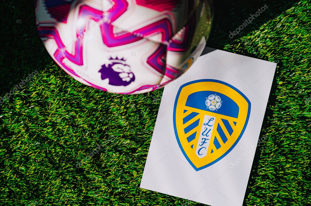 VIENNA, AUSTRIA, MAY 26, 2025: Leeds United logo of football club of Premier League. Official ball for season 2025 and 2026. And logo of soccer club in major British league on green grass
