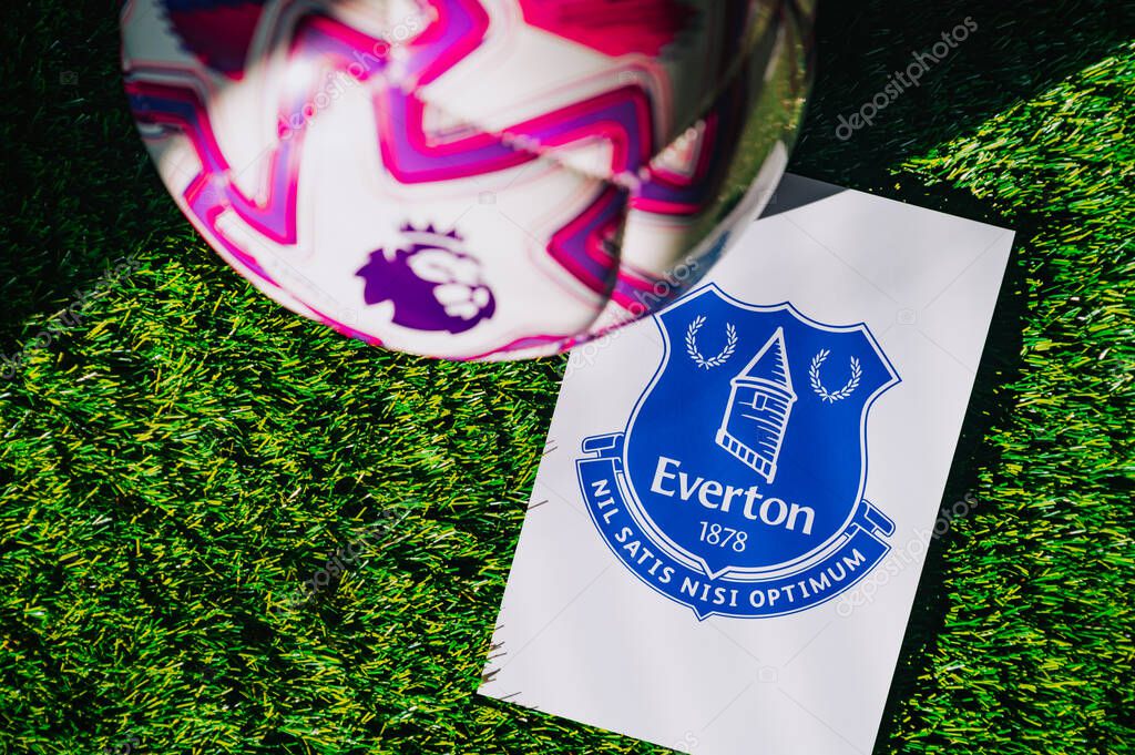 VIENNA, AUSTRIA, MAY 26, 2025: Everton logo of football club of Premier League. Official ball for season 2025 and 2026. And logo of soccer club in major British league on green grass