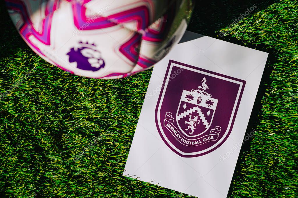VIENNA, AUSTRIA, MAY 26, 2025: Burnley logo of football club of Premier League. Official ball for season 2025 and 2026. And logo of soccer club in major British league on green grass