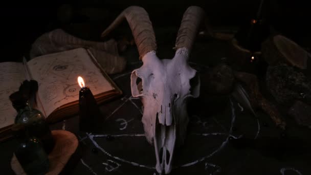 白色山羊与角雕琢 打开旧书 黑色蜡烛在巫婆桌上 神秘学 神秘学 占卜和邪恶的概念 万圣节 死亡日的概念 — 图库视频影像