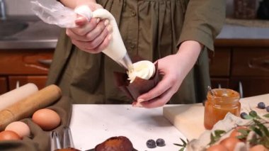 Çikolatalı keki krema ve taze yaban mersiniyle süslüyorum. Yemek poşeti, şekerleme, parti için kek yapmak, lezzetli keklerin üzerine krema sıkmak..