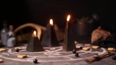 Kara büyü mumları yanar ve rüzgârın esmesiyle söner. Kara sanatın büyülü özelliklerinin arka planında duman var. Cadılar Bayramı ve Ölülerin Günü konsepti.