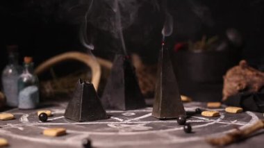 Kara büyü mumları yanar ve rüzgârın esmesiyle söner. Kara sanatın büyülü özelliklerinin arka planında duman var. Cadılar Bayramı ve Ölülerin Günü konsepti.