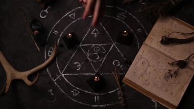 Kadın bir falcı falcının üst görüntüsü pentagramın arka planında sihirli kara mumlar yakıyor..