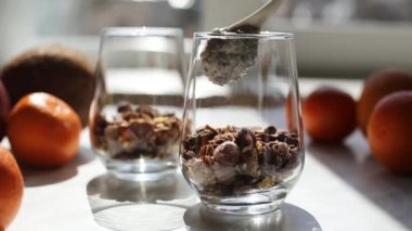 Hindistancevizi sütüyle chia tohumlarından puding yapma süreci. Cama chia tohumu yerleştirme işlemi. Sağlıklı vejetaryen yemeği. Mutfakta pencereden gelen güneş ışığı..