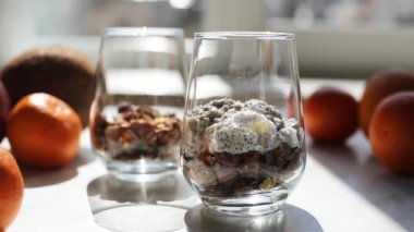 Hindistancevizi sütüyle chia tohumlarından puding yapma süreci. Cama chia tohumu yerleştirme işlemi. Sağlıklı vejetaryen yemeği. Mutfakta pencereden gelen güneş ışığı..