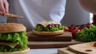 Pişirme işlemi ev yapımı sulu burger - malzemeleri adım adım katlamak. Şef fast food hazırlıyor..