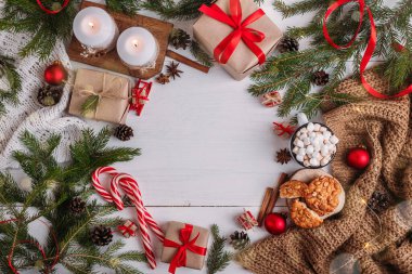 Noel tebrik kartı. Mum ve çelenk yakmak, köknar dalları, marşmelovlu kakao. Beyaz ahşap arka plan. Düz yat, boşluğu kopyala.