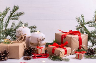 Noel kompozisyonu. Mum ve çelenk yakmak, köknar dalları, hediyeler ve kurdele. Beyaz kırsal arkaplan.