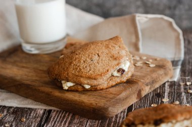 Süzme peynirli ve kuru üzümlü lezzetli kekler. Tahta masadaki köfteler. Ülke biçimi