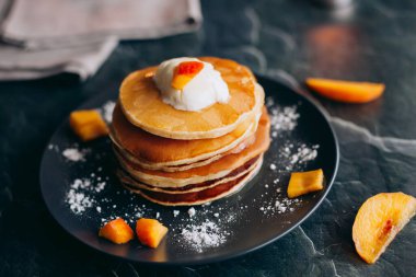Şeftalili krep, krema ve bal. Tabakta krep. Lezzetli kahvaltı.