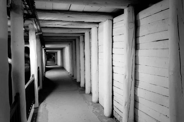 Un tunnel cavo nella roccia, un passaggio sotterraneo illuminato . — Foto Stock