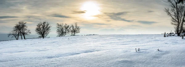 Tepelerde güneşli bir kış manzarası.