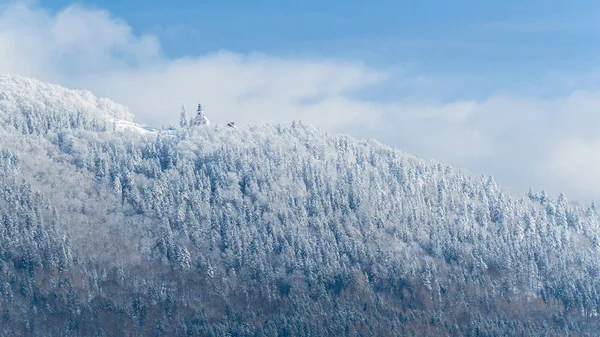 Paesaggio invernale polacco in montagna, alberi innevati con una chiesa in cima . — Foto Stock