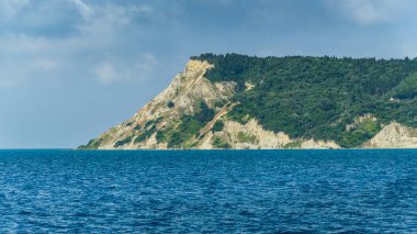 Korfu, Paxos Sahili, mavi deniz üzerinde yüksek kayalıklar.