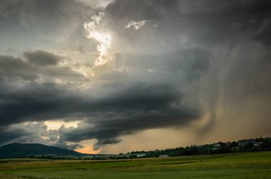 Dağların üzerinde kara fırtına bulutları, yağmur.