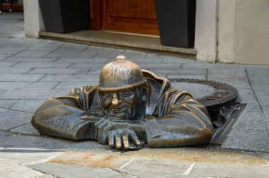 Bratislava, kanal yapıcı açık bir kanalizasyon ambarı dışarı eğilerek.