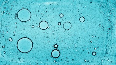 Yuvarlak yağ kabarcıkları su yüzeyinde yüzer. Farklı boyutlardaki dairelerin üst görünümü.