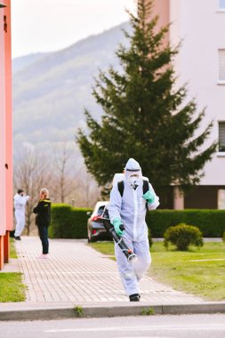 Bystrzyca Klodzka, Polonya - 28 Nisan 2020: İtfaiye tarafından şehrin sokaklarının dezenfekte edilmesi. Koruyucu giysiler giymiş itfaiyeciler virüslerden arınmış kaldırımlar..