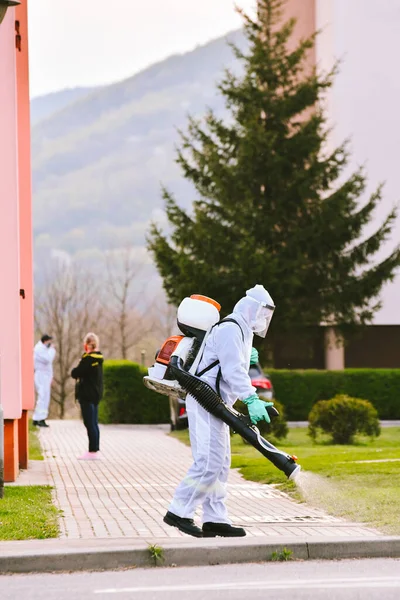 Bystrzyca Klodzka, Polonya - 28 Nisan 2020: İtfaiye tarafından şehrin sokaklarının dezenfekte edilmesi. Koruyucu giysiler giymiş itfaiyeciler virüslerden arınmış kaldırımlar..