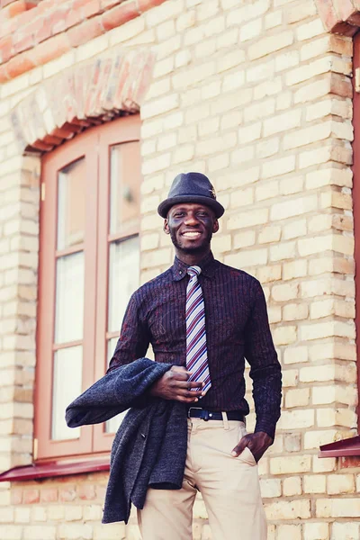 happy young black african man with near bricks building
