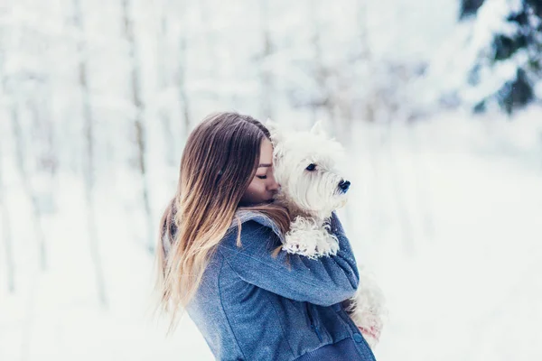 portrait of a woman hugging a dog in the winter forest. Concept of friendship and devotion